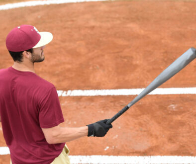 Male athlete with red shirt holding a bat